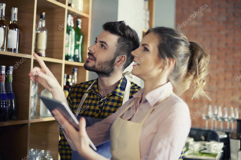 Barra de bar organizada mientras el bartender usa una app de control